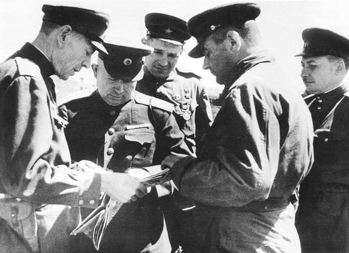 Заместитель командира 6-й гвардейской армии гвардии генерал-майор Павел Филиппович Лагутин (1896 – 1975), член военного совета Воронежского фронта генерал-лейтенант Никита Сергеевич Хрущёв (1894 – 1971), Герой Советского Союза начальник отдела по работе в танковых войсках Политуправления Воронежского фронта гвардии майор Тимофей Максимович Шашло (1915 – 1989), командующий 5-м гвардейским Сталинградским танковым корпусом генерал-майор танковых войск Андрей Григорьевич Кравченко (1899 – 1963) у карты во время боёв на Курской дуге. Автор неизвестен. Июнь 1943 г. 5-2.jpg