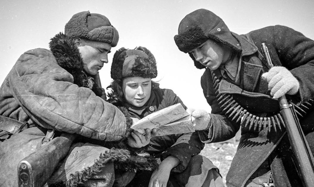 Командир партизанского отряда Будаков показывает разведчикам Марии Ельник и Павлу Киселёву карту боевых действий в деревне западнее Курска. Партизаны во многом помогали Красной армии перед сражением на Курской дуге. Февраль 1943 г. Фото: Семён ФРИДЛЯНД. 1943 г. 4-2.jpg